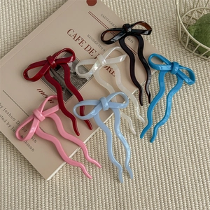 Chic ballet-style bow hairpins in multiple colors on a natural woven mat background