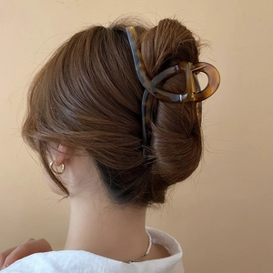 Detail of large leopard print hair claw clip securing a French twist hairstyle on a model