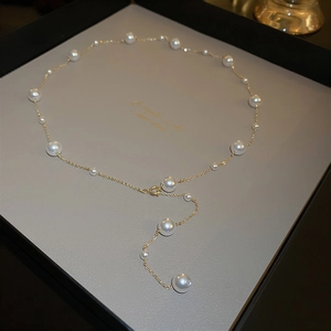 Elegant gold Y-shaped necklace featuring polished white pearls on a minimalist chain
