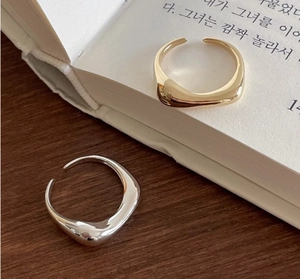 Detail von minimalistischen unregelmäßigen offenen Ringen in Gold und Silber