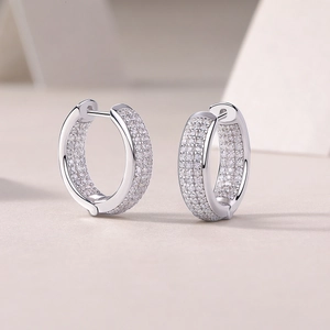 Elegant silver circle hoop earrings with double-row moissanite stones on textured surface