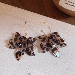Detailed view of leopard print resin flower C-shape earrings with gold hooks
