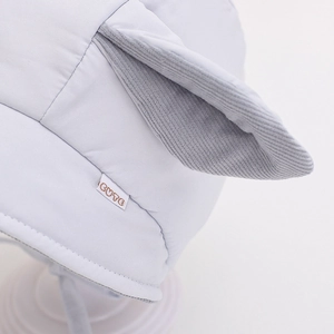 Macro view of cute corduroy rabbit ears on a soft blue infant warm pullover hat