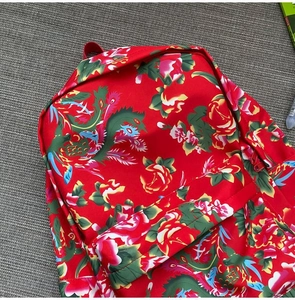 Detail of traditional Chinese floral pattern backpack in vibrant red nylon fabric