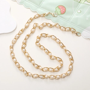 Detail view of golden metal chain strap with white pearls for mobile phone DIY or handbags