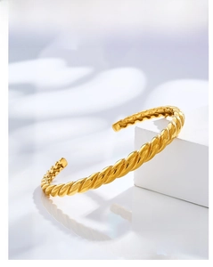 Detailed view of a gold titanium steel twisted cuff bangle with a polished finish