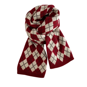 Close-up of red and beige argyle knit scarf with premium soft wool texture for winter