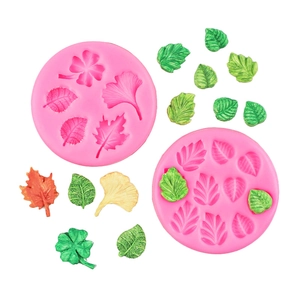 Detail of pink silicone leaf molds with finished green and yellow fondant leaf shapes