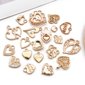Detailed close-up of mixed KC gold hollow heart pendants and charms for jewelry making