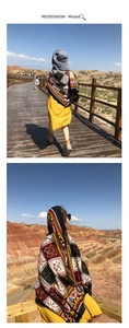 Ethnic print shawl with tribal patterns and tassels shown in a scenic outdoor setting