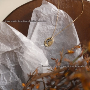 Detail of vintage oval pendant with silver crescent moon and golden star on a fine gold chain