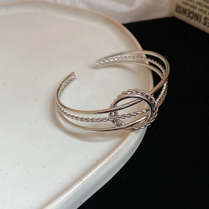Detailed macro view of silver twisted metal bangles on white ceramic edge