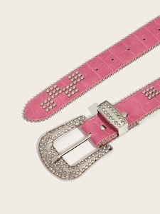 Close-up of pink crocodile texture belt with sparkling rhinestone buckle and studs