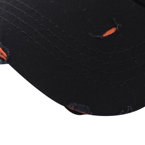 Detalle de gorra de algodón desgastada con bordes rasgados y forro naranja visible