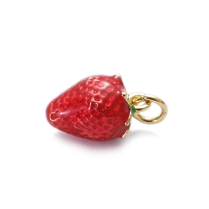 Macro view of strawberry enamel pendant with gold leaf and textured red finish