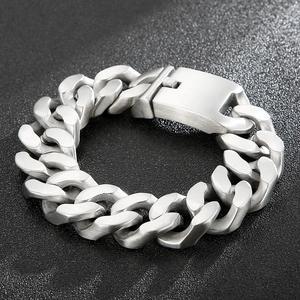 Macro detail of men's silver stainless steel Cuban chain bracelet with brushed finish