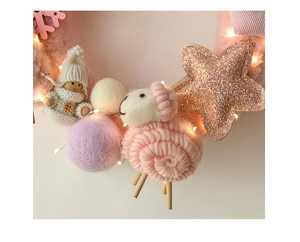 Detail of Christmas wreath with pink wool sheep, snowman, felt balls and warm LED lights