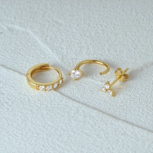 Macro detail of 3-piece S925 sterling silver gold earrings set with zircon stones