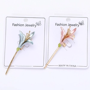 Detail of blue and pink enamel lily flower hair pins with pearlized finish on white card