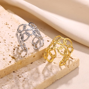 Detail view of gold and silver cutout rings with interlocking bands on stone