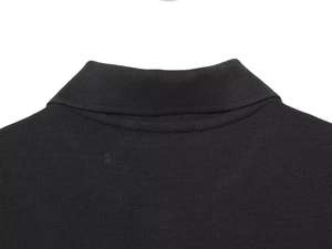 Detailansicht des gerippten Polokragens und der Strickstruktur dieses schwarzen Kleides