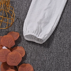 Détail du poignet blanc à manches longues avec texture gaufrée plissée et élastique