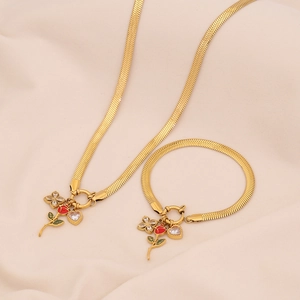 Detail of gold snake chain set with red rose flower and crystal heart charms