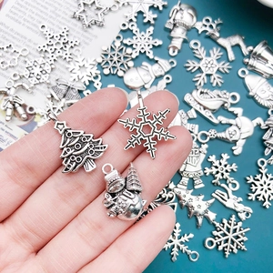 Close-up of vintage silver alloy Christmas charms including snowflakes and reindeer