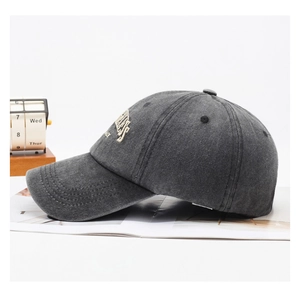 Detail view of washed dark grey baseball cap with white side embroidery and vintage texture