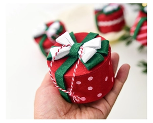 Close-up of handmade red felt Christmas gift box with white polka dots and green bow