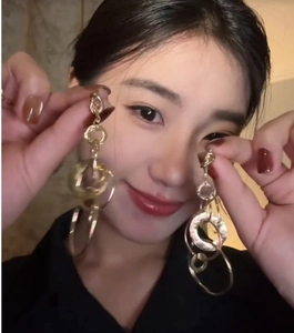 Close-up of stylish gold layered circular hoop earrings worn by a model for a trendy look
