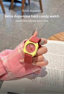 Detail of square candy-themed quartz watch with yellow case and red silicone strap