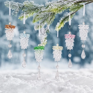 Set of six colorful acrylic pine cone ornaments hanging on snow-covered pine branches