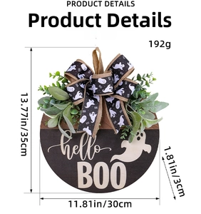 Detail of wooden Halloween Boo door sign with eucalyptus leaves and a ghost ribbon bow