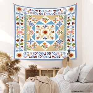 Detail of bohemian mandala tapestry with floral patterns and motivational quote in bedroom