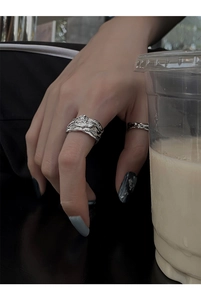 Detail of silver irregular lava texture rings with metallic luster on model's fingers