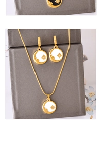 Detail view of gold necklace and sunburst earrings set with white enamel inlay