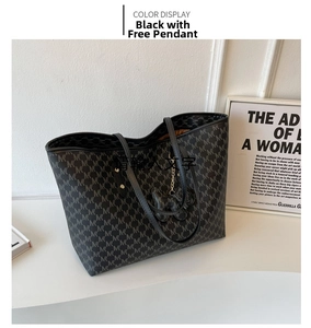 Detalle de bolso tote negro con estampado de letras M y colgante de animal negro