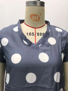 Detail of V-neckline and white polka dot pattern on navy blue short sleeve dress