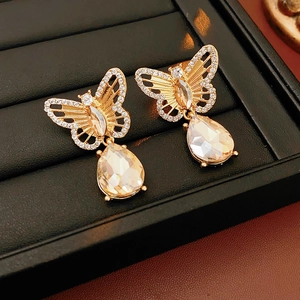 Gros plan de boucles d'oreilles papillon vintage dorées avec pendentifs en cristal goutte