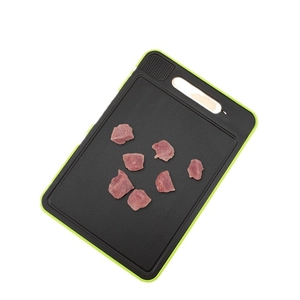 Black non-slip defrosting cutting board with green edges and integrated meat grinder area