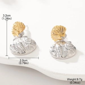 Detail of seashell stud earrings with mixed gold and silver ocean star engraving