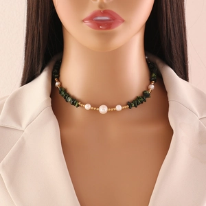 Detail of handmade necklace with green natural stones and white pearls on a model