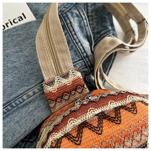 Detail of colorful geometric woven fabric and beige canvas strap with metal zipper
