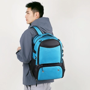 Side view of sky blue waterproof sports backpack worn by a model in a gray jacket