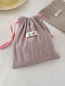 Pink striped drawstring storage bag for travel cosmetics with woven brand label