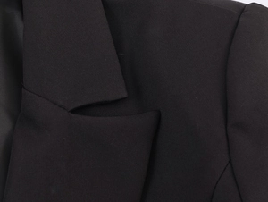 Detailed macro view of black blazer fabric texture and clean neckline stitching details