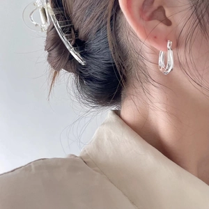 Close-up of model wearing polished silver U-shape 925 sterling silver geometric earrings