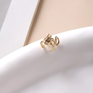 Vue macro d'un earcuff grenouille punk doré avec texture métallique et forme animale