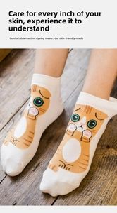 Detail of white cotton sock featuring a cute orange cartoon cat pattern and soft texture